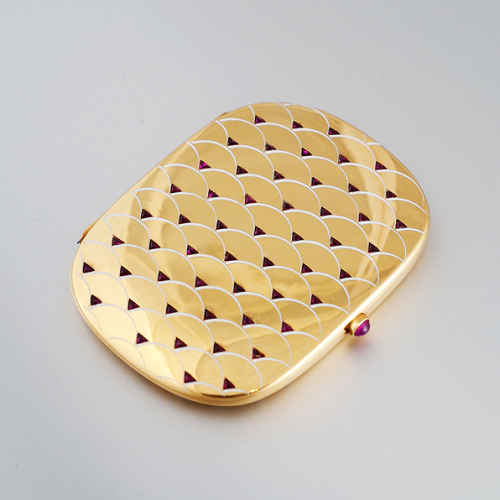 Lacloche Freres, Fancy 18K gold card case inset with 54 triangle cut Rubies (approx. 10 carats TW), an oval cabochon ruby for the closure button and champleve arching white enamel scallop details on the front and back, 18K gold, signed, c. 1930