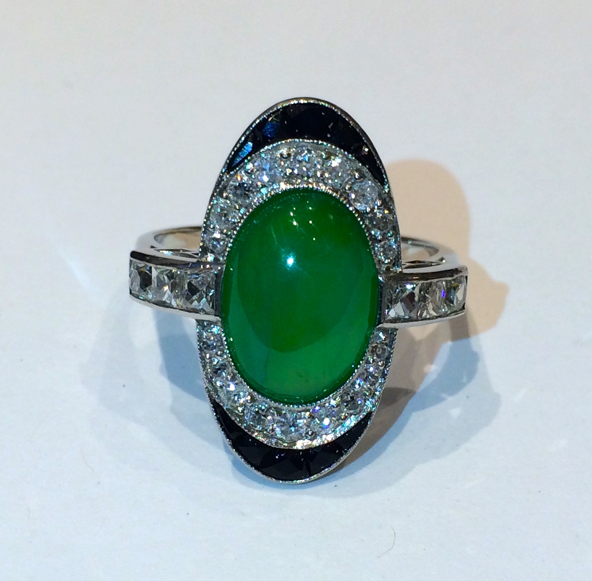 French Art Deco ring set with a fine jadeite oval cabochon, faceted and caliber cut onyx, and further set with 18 round diamonds and six square French-cut diamonds all set in a millegrain platinum mount, c. 1920’s