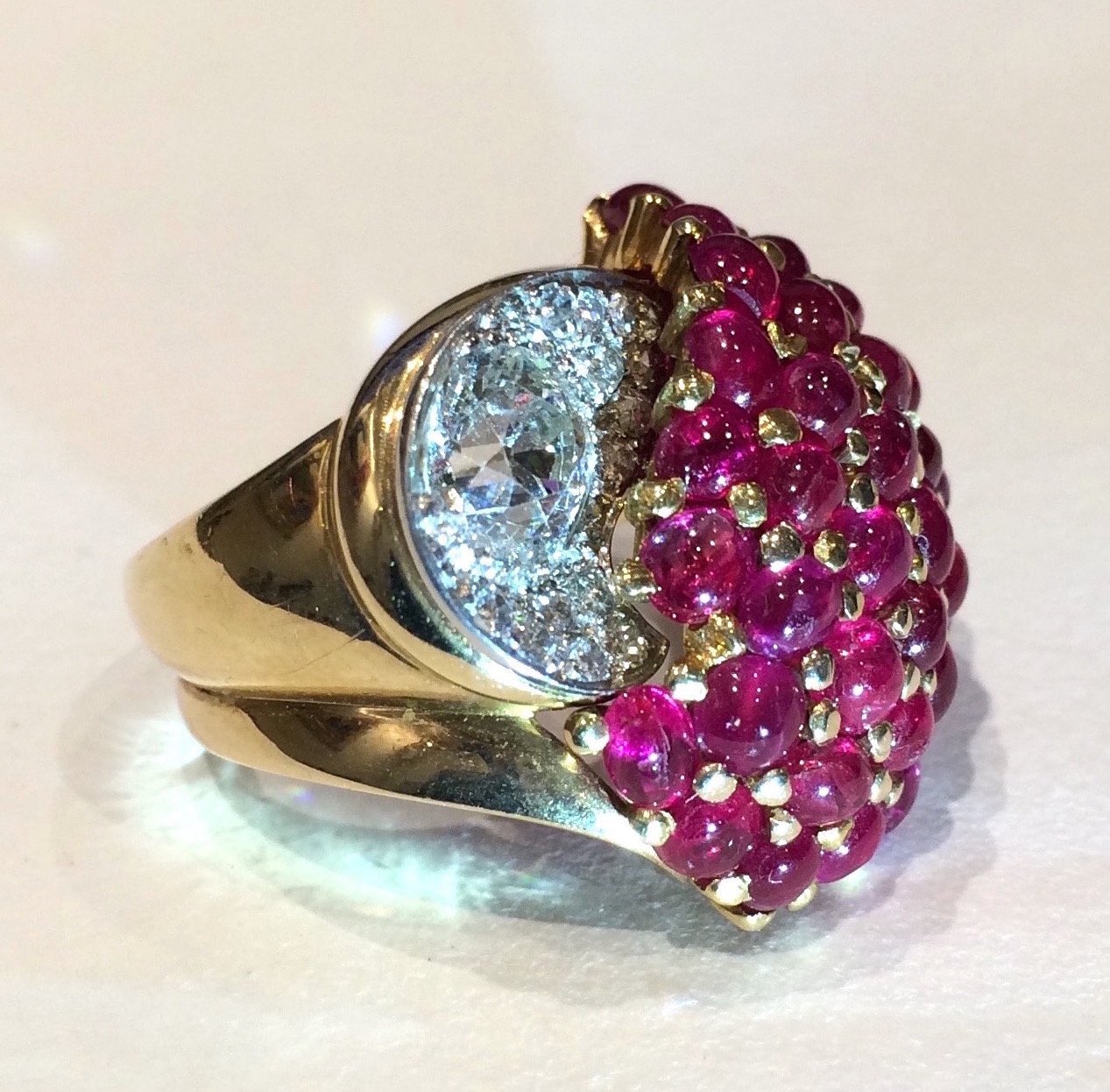 Paul Flato, (1900-1999) Hollywood, New York (attr.) “Cluster” ring in 18K yellow gold and set with 39 cabochon rubies (approx. 8 carats TW) and further set with a center round brilliant cut diamond (1+ carat TW) and an additional 14 round pave set diamonds in platinum, c. 1940