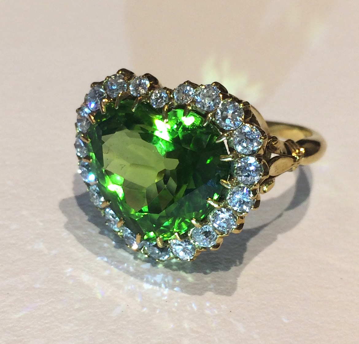 American Art Nouveau “Green Heart” ring set with a heart shaped peridot (approx.15 carats) surrounded with 20 round cut diamonds (approx. 3 ½ carats TW) all set in an 18K gold mounting, c.1900