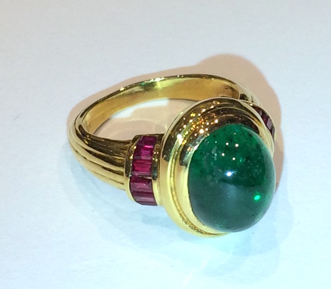 Albert J. Pujol ring set with a cabochon emerald (6 carats) and 14 invisibly channel set rubies in an 18K gold mount, marked, c. 1970’s