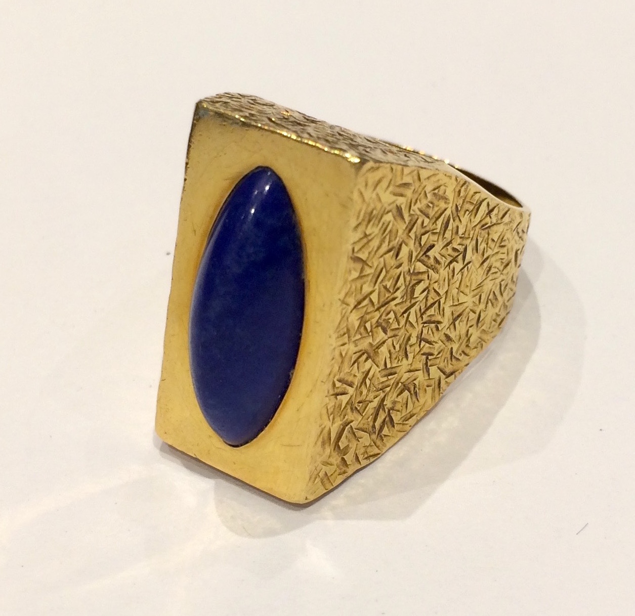 Andrew Grima, “Egyptian” textured 18K gold and elongated cabochon lapis lazuli  ring, signed and British date marks for 1972