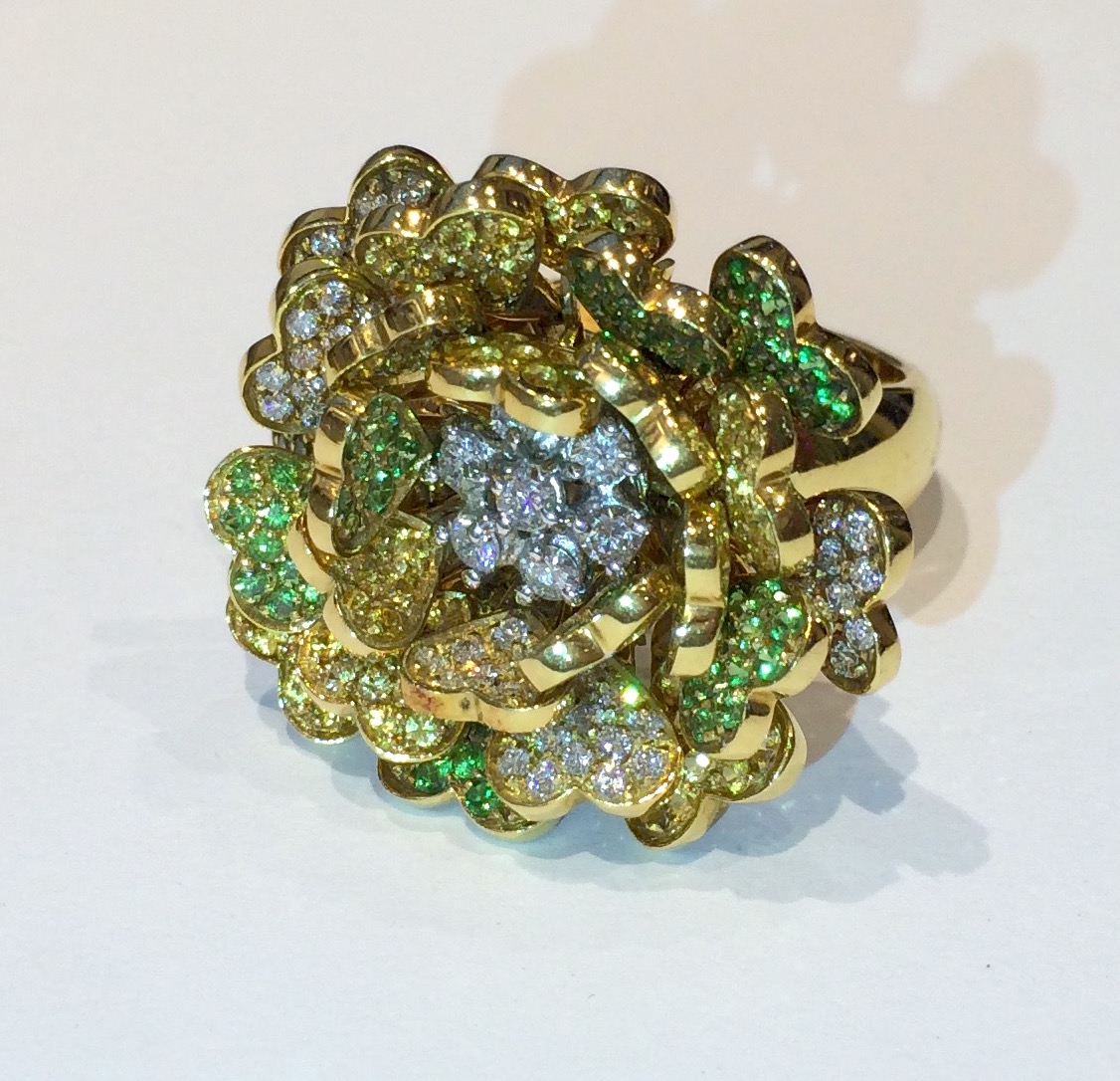 Chanel, Paris “Camellia” 18k yellow gold articulated blossom ring set with 75 round full-cut white diamonds (approx. 1.50 carats TW) and 101 round full-cut yellow diamonds (approx. 1.00 carat TW) and 94 round full-cut demantoid garnets (approx. 1.00 carat TW) all in 24 heart shaped hinged and moveable flower petals with a central cluster of 7 round full-cut diamonds, signed: Chanel in a rectangle, 750 in a cartouche, size: 7 1/4, c. 1980’s