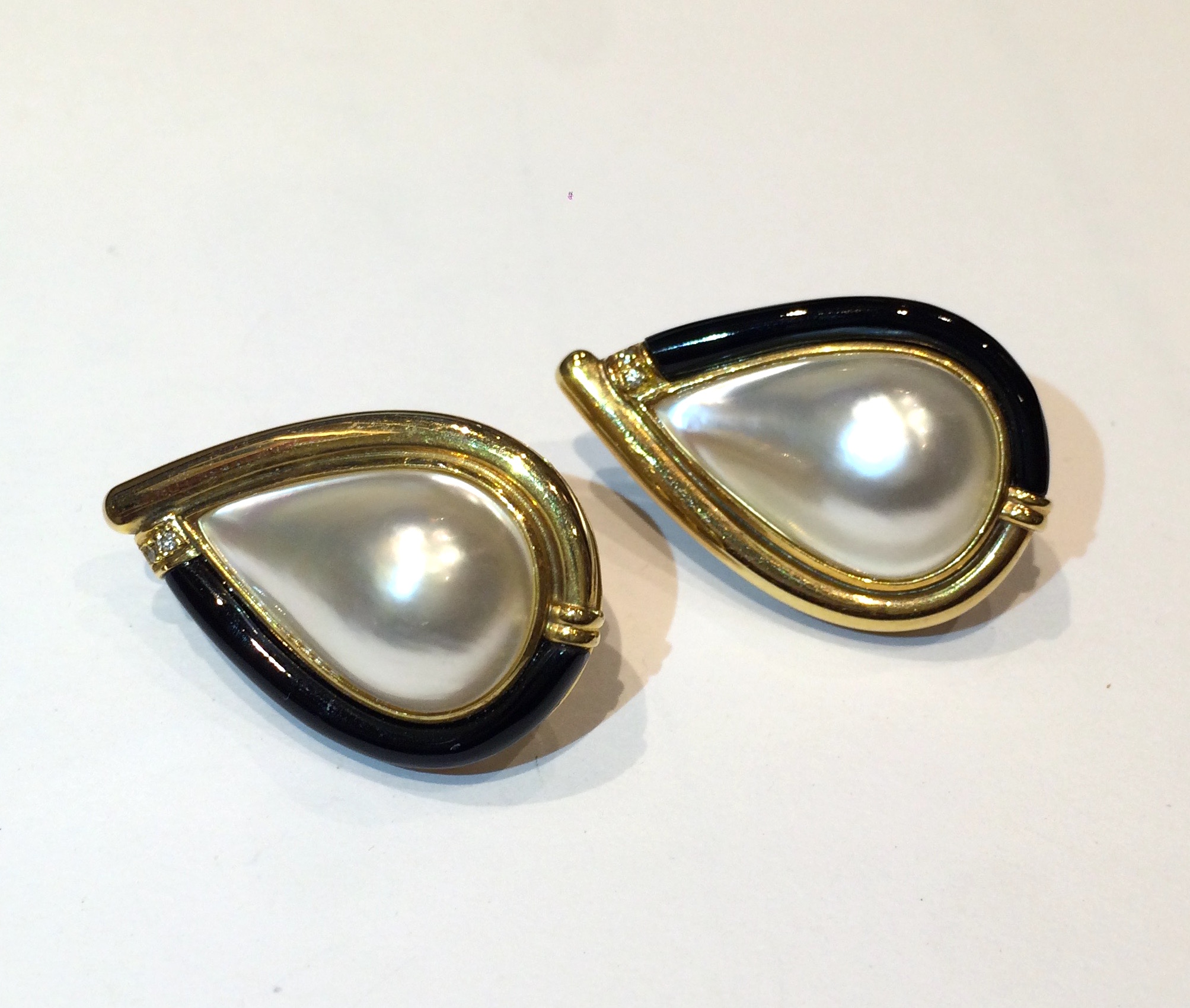 European pear shape clip earrings set with large mabe pearls, contoured onyx all in a yellow gold mount and further set with four round cut diamonds, marked, c.1980’s