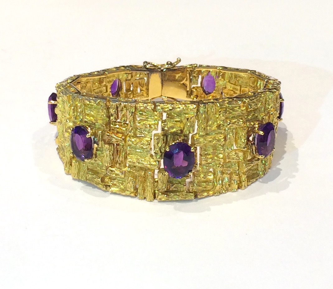 H. Stern, Rio de Janeiro, Brazil highly textured and sculptural tapered bracelet in 18K gold set with 7 oval gem quality amethysts (approx. 14 carats TW) Marked: 750 mark, S (H. Stern mark) in a diamond, c. 1960’s