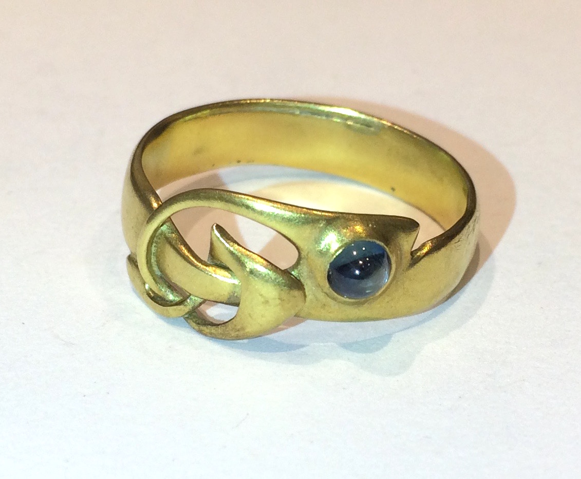 Archibald Knox / Liberty & Co. “Celtic Knot” ring, Gold set with a cabochon blue sapphire, c. 1902