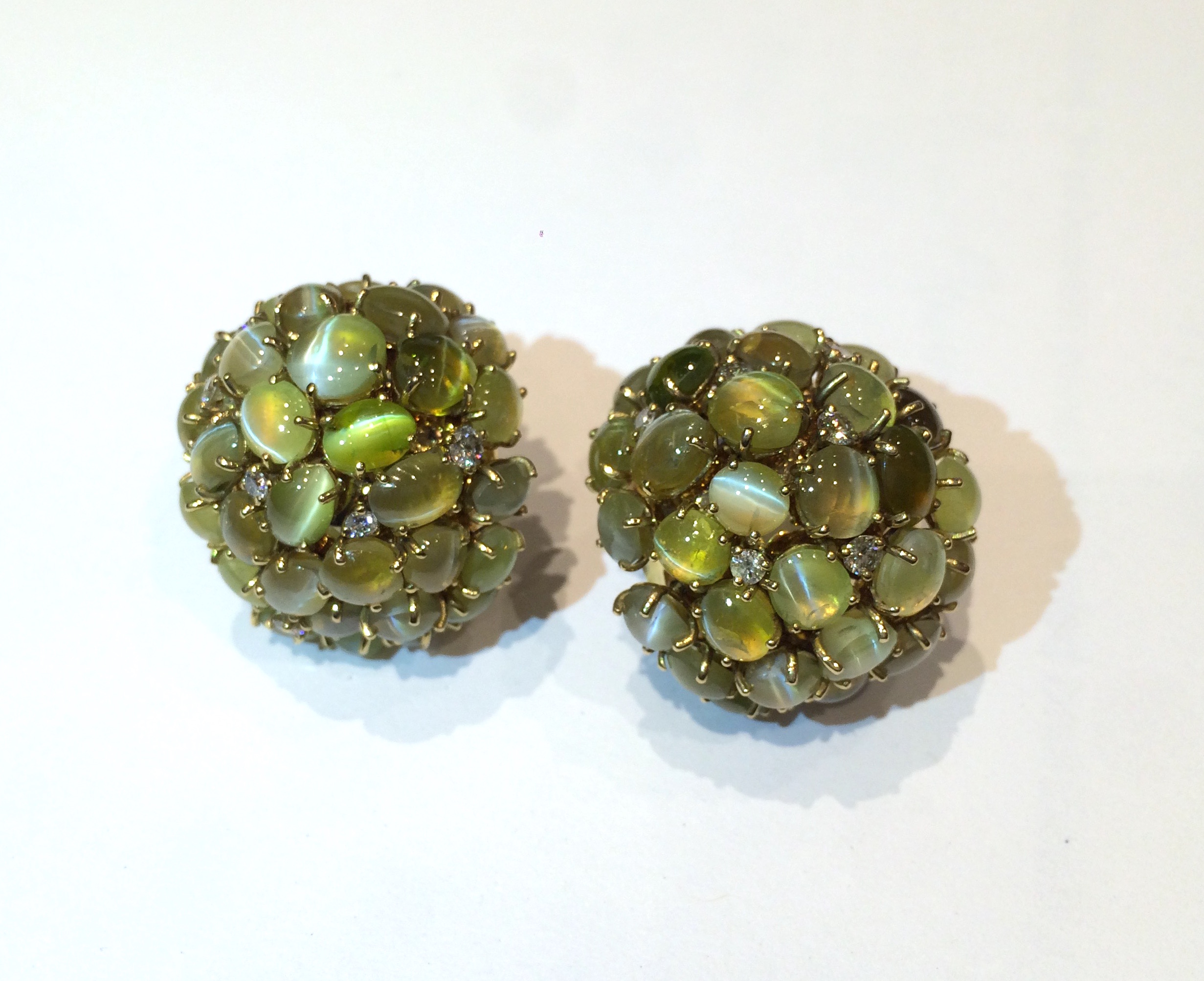 “Cat’s Eyes” bombe clip earrings, 72 fine and rare color cabochon chrysoberyl “Cat’s Eyes” and 12 interspersed diamonds, all set in 18k gold, marked, c. 1950’s