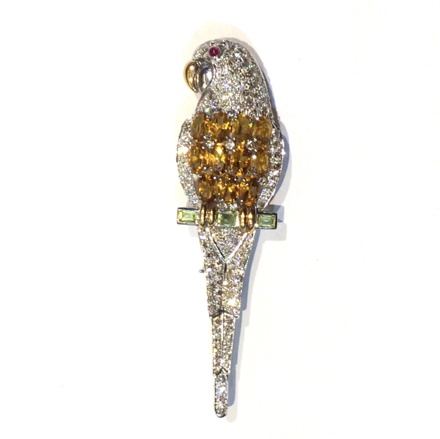 Trabert & Hoeffer, Mauboussin Art Deco “Parrot” brooch, 18k white and yellow gold set with 11 oval citrines (approximately 5 carats tw), three peridot baguettes and a cabochon ruby eye all further set against a pave diamond body (approximately 7 carats TW, 120+ count), signed, c.1935
