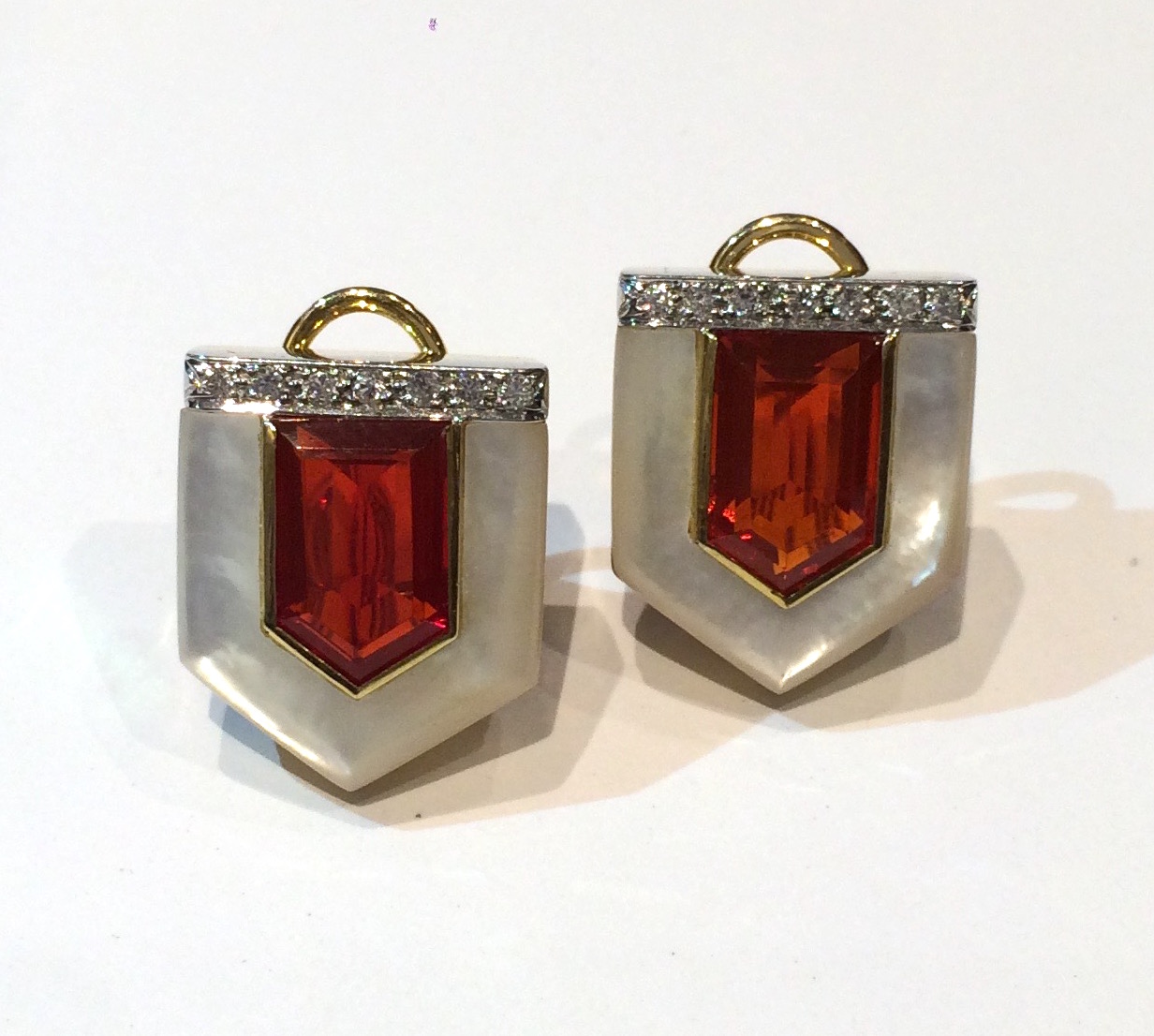 European “Arrow” clip earrings set with a large central pentagon shaped fire opal surrounded with a contoured mother of pearl bezel and further set with 14 diamonds in 14K white and yellow gold, marked, c. 1980’s