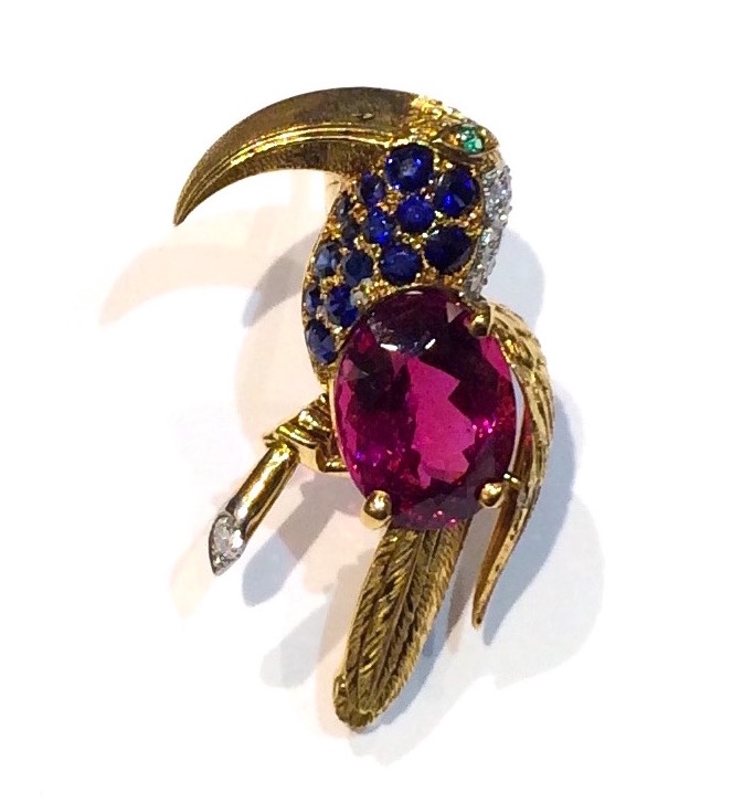 French Retro “Bird” brooch set with a large oval gem quality “Rubellite”/ Tourmaline (approx. 9 carats TW, G.I.A. certificate, 15.20 x 11.55x 7.90mm, no heat), sapphires, diamonds and an emerald eye all set in 18K yellow gold, marked, c. 1940’s