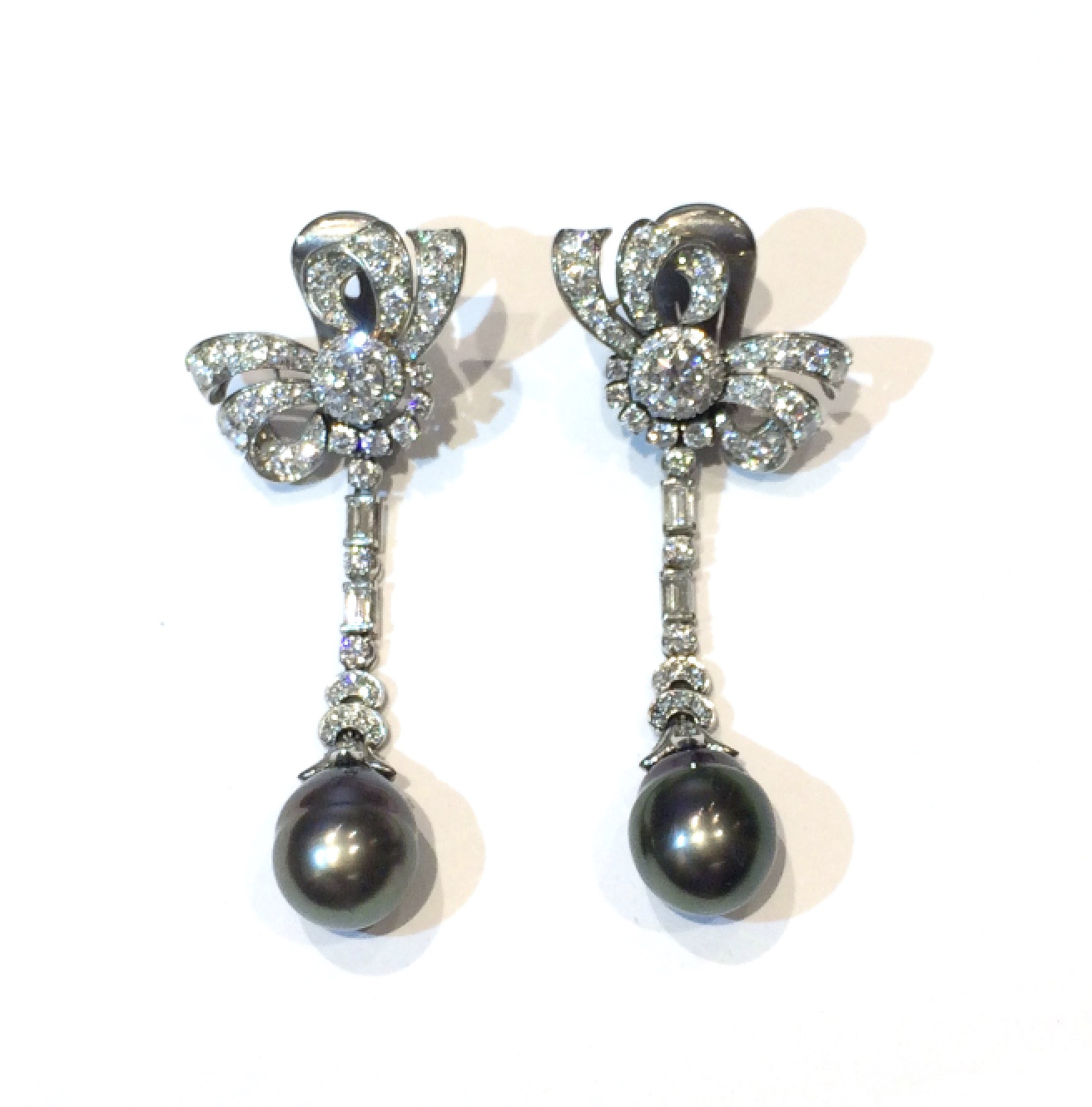 American “Night & Day” pendant earrings, two black pearls suspended from fancy detachable pendants with a bow motif earrings all set in platinum with approx. 134 round diamonds and four baguette diamonds (approx. 8 carats TW), c. 1935
