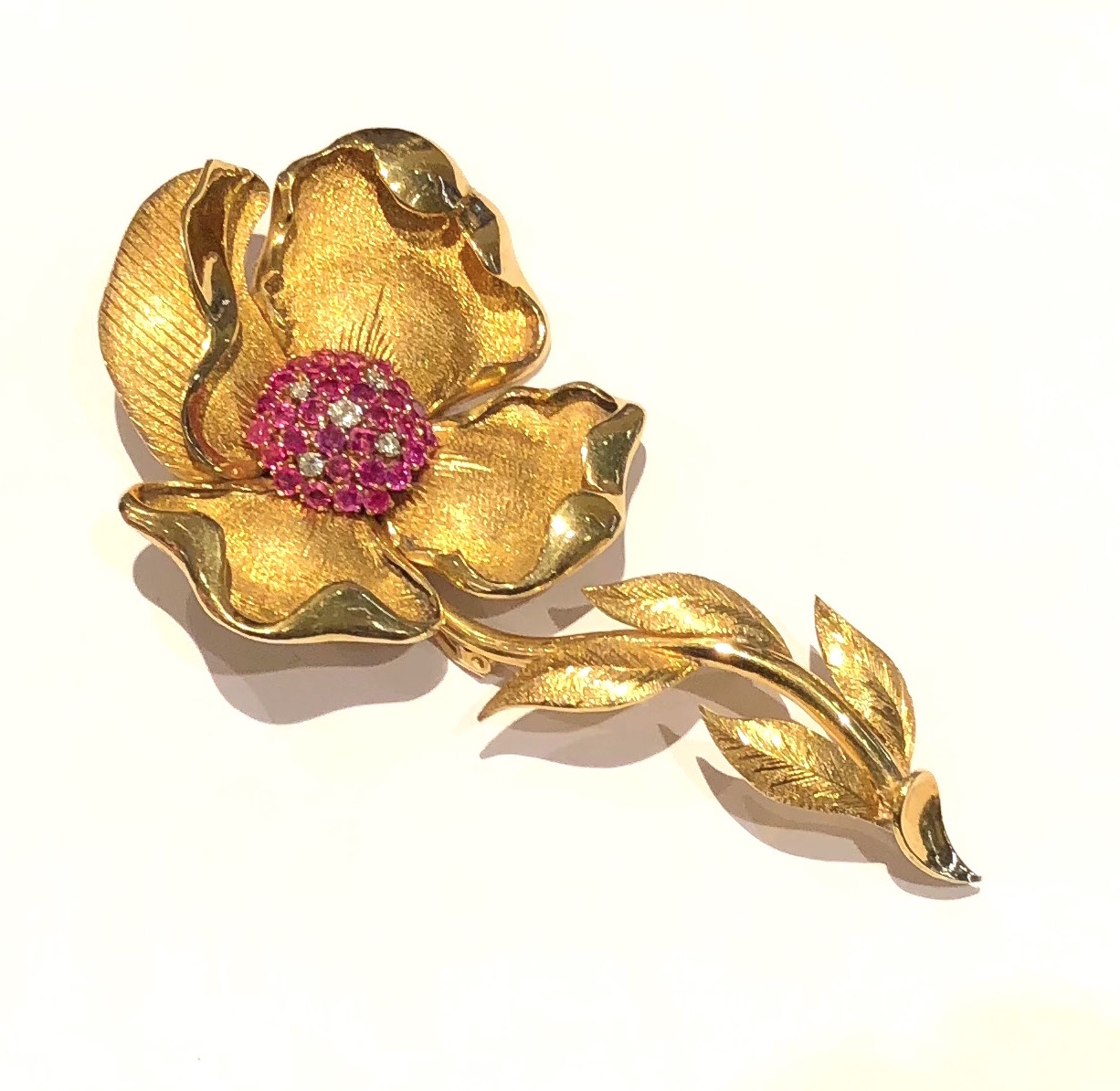Flower blossom brooch in 18K textured and contoured gold set with 31 round cut rubies (approx. 3.50 carats) and 5 round cut diamonds (approx. 0.5 carat TW) c.1940’s