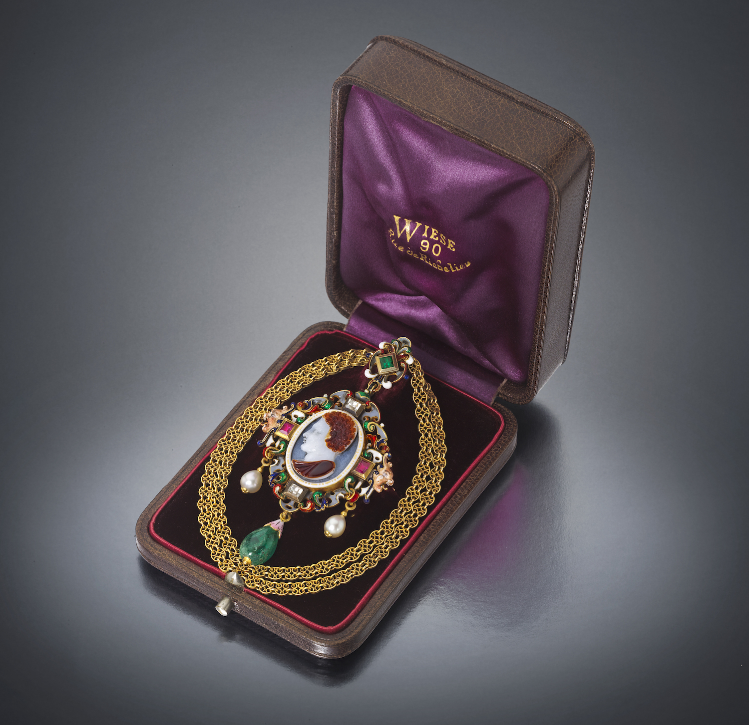 Jules Wiese (1818-1895) / Louis Wiese (son of Jules, 1852-1923) Renaissance Revival jeweled and enameled 18k gold pendant necklace set with an ancient carved carnelian cameo, table cut diamonds, rubies and an emerald, two natural pearl drops and a cabochon emerald drop with the original chain, signed, original leather box with and silk velvet and satin interior, c.1875