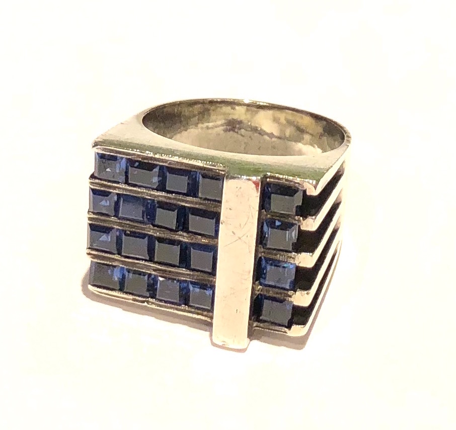 Margaret De Patta (1903-1964) Modernist asymmetric sterling ring set with twenty square cut sapphires (approx. 9 carats TW ), signed: DePatta, Chevron mark of MDP, Sterling, c.1947