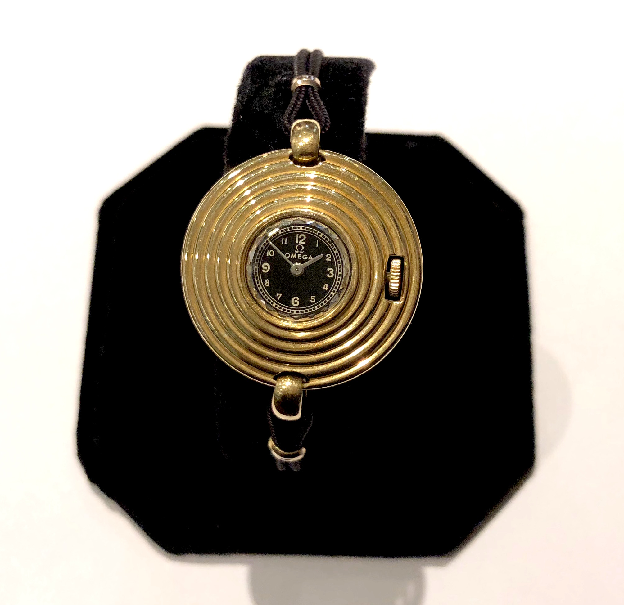 Omega Swiss Art Deco “concentric ring” round face watch, 18K gold with a big jeweled round crystal face and black strap band, signed, c. 1930’s