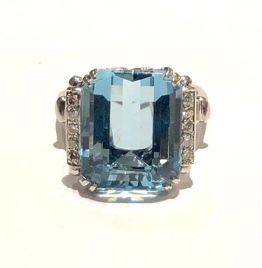 American Art Deco ring set with a large gem quality emerald step-cut aquamarine (approx. 15 carats by calculation with the dimensions of 17mm x 13mm x 10mm depth) and 10 round cut diamonds (approx. half of a carat TW) all set in a platinum “Bow tie” design mount, signed: FFF framed with a triangle facing in on either side (maker’s mark), Plat (platinum mark), c.1935