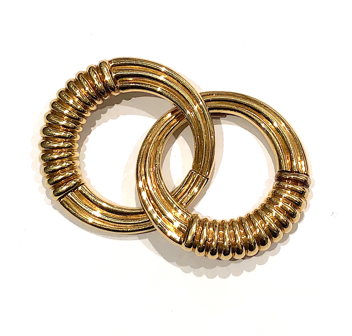 Van Cleef & Arpels circular stylized clip brooch in 18K gold with a ribbed motif, signed: VCA, Or, 750, copyright 88, VCA French touchmark in a diamond, no. B3378R5, c. 1980’s