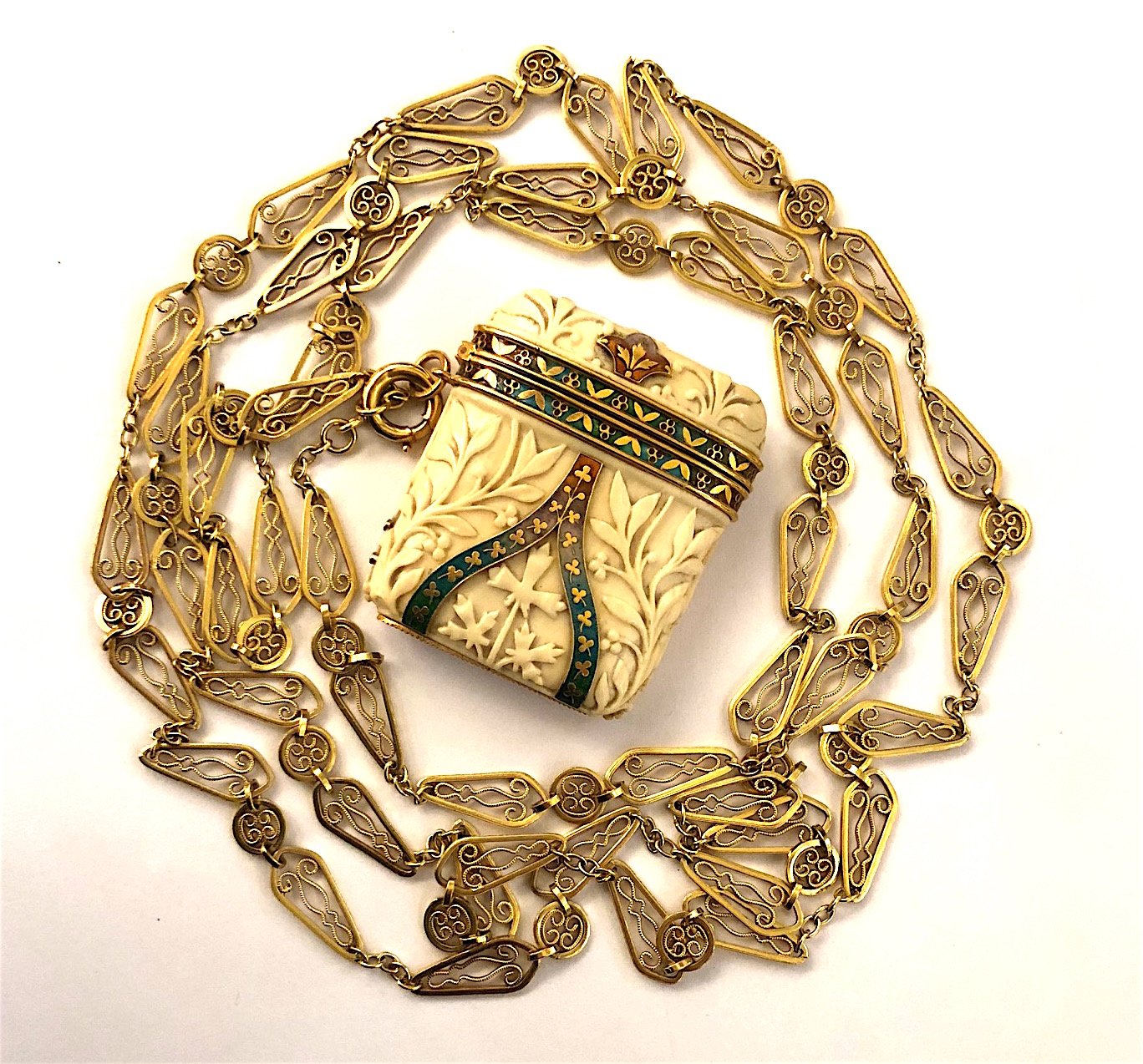 Tiffany & Co., New York Neo-Gothic “Vesta” case with 18k gold mountings and polychrome champleve enamel details on a “bone” covered case with hand carved foliate details on an 18k gold French “Belle Epoque” long chain, Tiffany & Co. Vesta signed: Tiffany & Co. (2x), LS in a diamond cartouche, mark for Georges Le Sache, 346 rue St.-Honore, 75001, Paris, French Eagle’s head mark for 18k gold (2x), French “Belle Epoque” long chain signed: Diamond shaped makers cartouche (2x), French Eagle’s head mark for 18k gold (3x), French Rhinoceros and Weevil 18k gold assay marks for small pieces, c. 1880