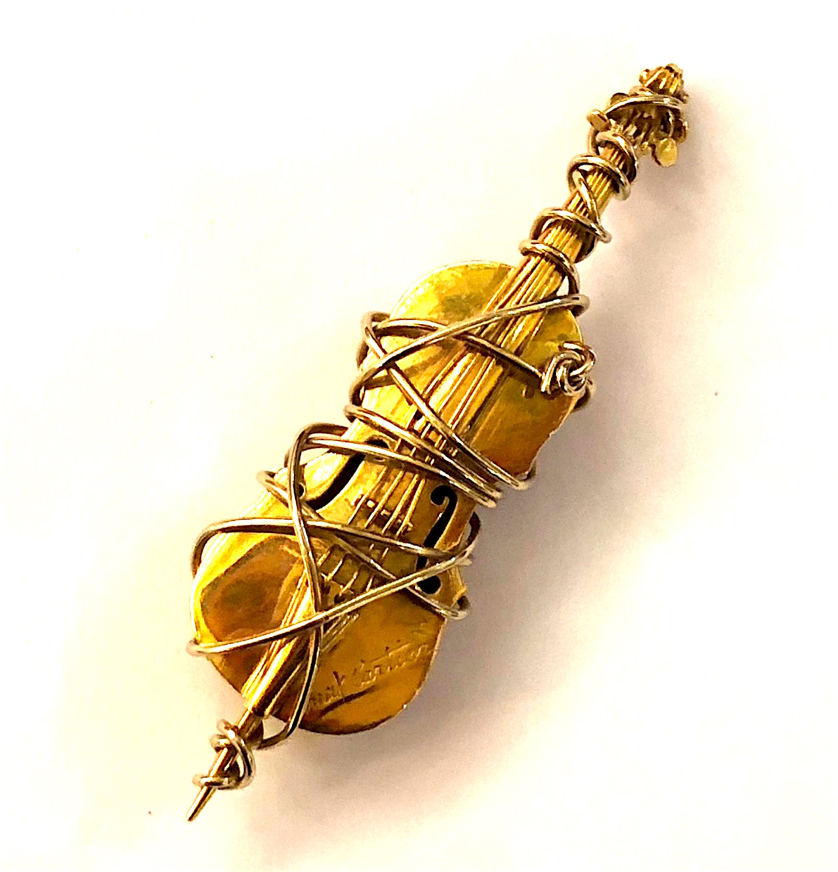 Max Cartier, Paris (born 1935, Film Director, Sculptor) 18K yellow and white gold signature “wrapped” bass or cello sculptural brooch. Signed: Max Cartier (script signature) on lower front right, French maker’s mark with an A L in a diamond poincon, French mark with a M C in a diamond poincon for Max Cartier (2x), French Eagle’s head touch mark for 18k gold (2x), c.1980