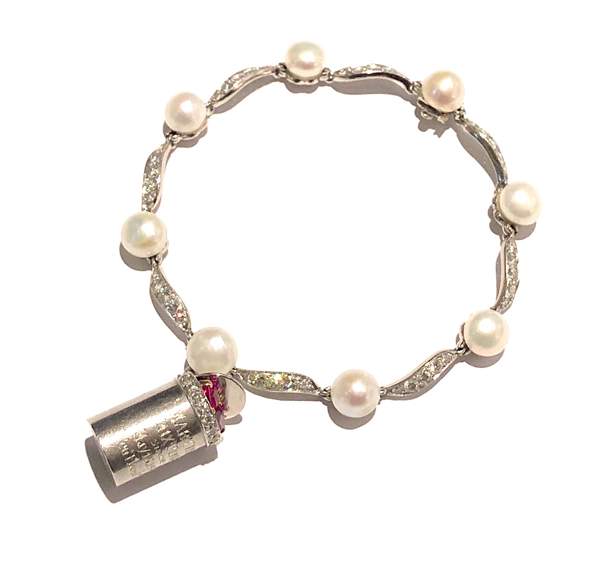 William Ruser  Los Angeles “Charisse” 10 year anniversary bracelet, 1958 platinum set with diamonds and 8 pearls and further set with a double ruby heart charm that was given to Cyd Charisse by Tony Martin for their 10th wedding anniversary on May 15, 1958.  It is engraved: Martin’s Mixture since May 15, 1948 Ten Fluid Years “Taint Tin” (They were married for 60 years) Signed and marked: Ruser, Made in California, 10% irid Plat