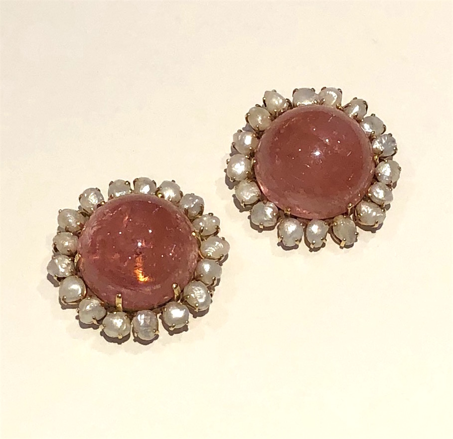 Seaman Schepps, (1881-1972) Founded 1904, New York “Flower” matched pair of brooch/pendants, each brooch set with a half round of a large pink tourmaline Mughal bead (approx. 122 carats each for a total of 244 carats), each set with seventeen natural baroque pearls (34 count total) encircling each pink tourmaline cabochon and all set in a yellow gold mounting with both a double pin back and a pendant bale on each, marked: 14k, c. 1940