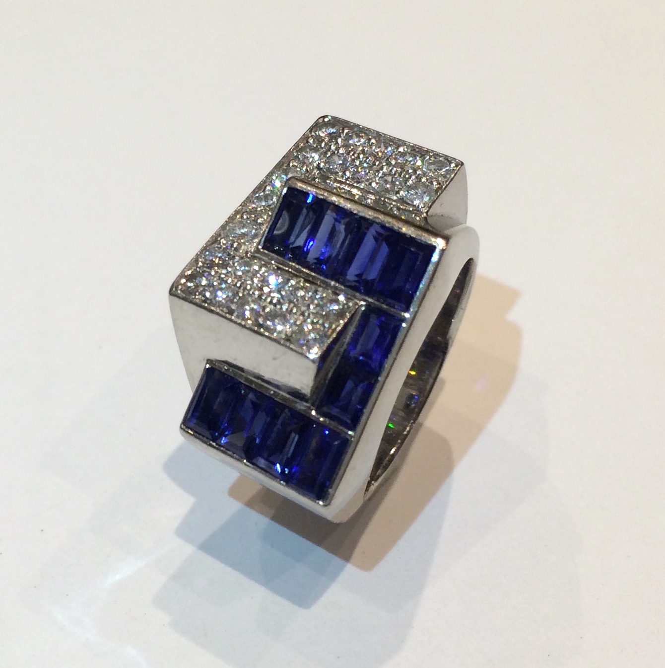 French Art Deco Interlocking ring, Invisibly set rectangular sapphires (10 count, approx. 2.50 carats TW), pave diamonds (approx. 2.50 carats TW) all set in a platinum mount, c. 1935