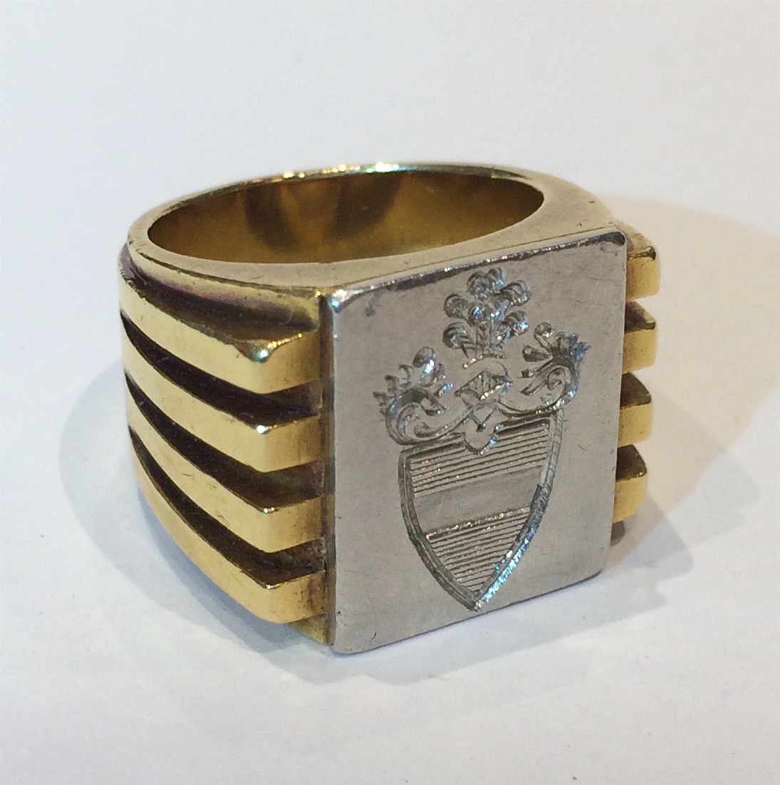 Van Cleef & Arpels, New York, Art Deco “Heraldic” ring in 18k gold with stylized geometric flanges on either side of the platinum rectangular plaque with an intaglio carved Coat of Arms, signed Van Cleef & Arpels, NY, 9398, c.1930