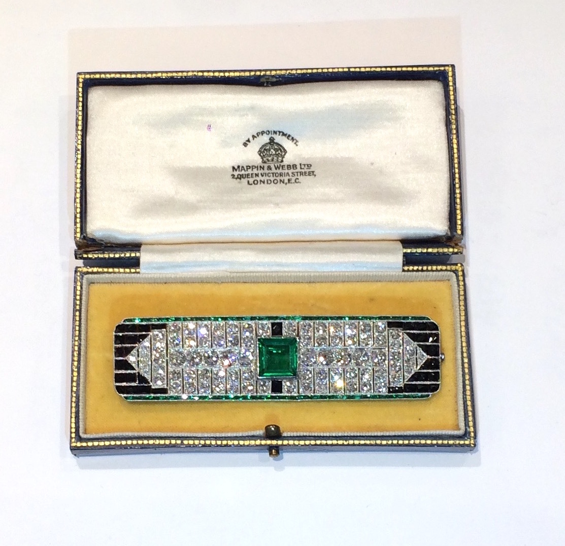 Mappin & Webb Art Deco / Modernist diamond brooch (84 count approximately 14 carats TW), further set with fully faceted onyx and emeralds with a central square synthetic emerald all set in an elaborate platinum mount, c.1930